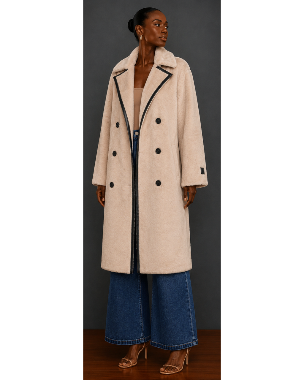 Front view of woman wearing a beige coat with black buttons against a gray background