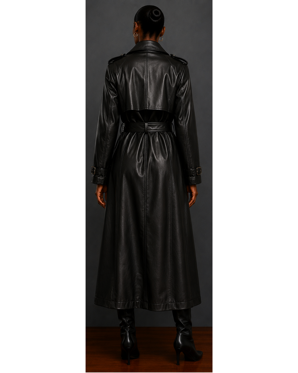 Back view of woman wearing a black leather trench coat against a gray background