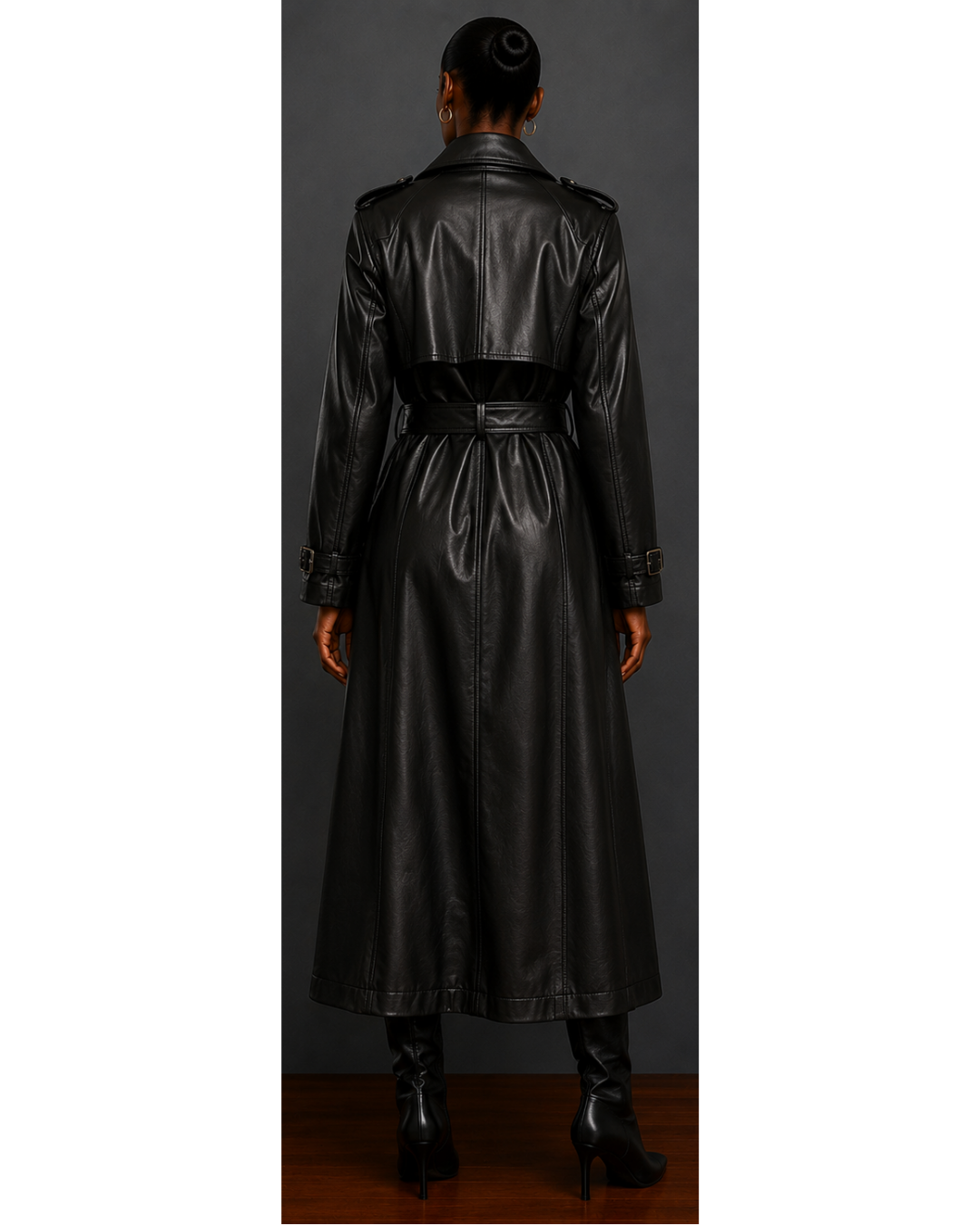 Back view of woman wearing a black leather trench coat against a gray background