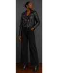 Person wearing a black leather jacket and pants against a gray background