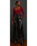 Front view of a woman wearing a red top and black leather skirt against a dark background