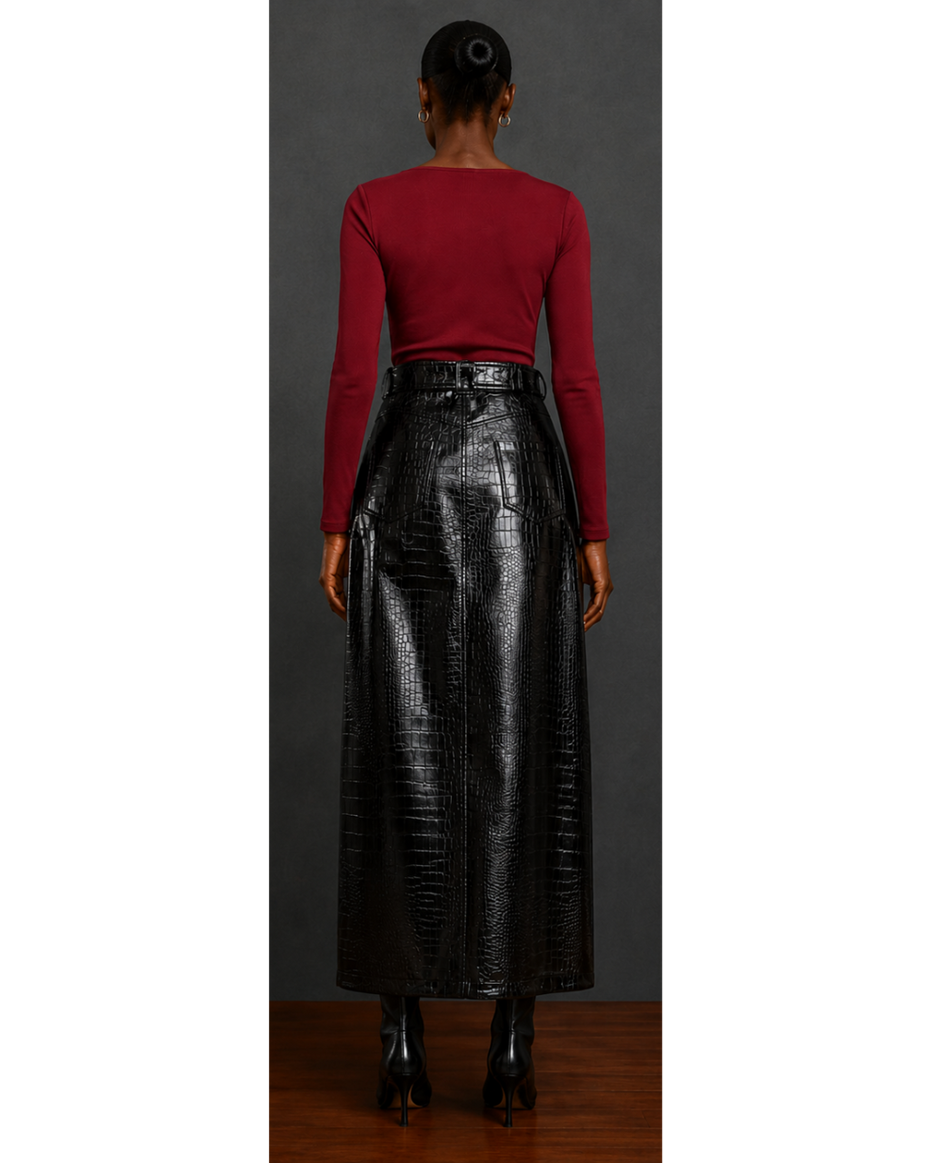 Back view of woman wearing a red top and black leather skirt against a gray background