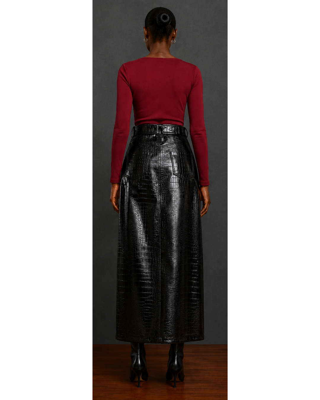 Back view of woman wearing a red top and black leather skirt against a gray background