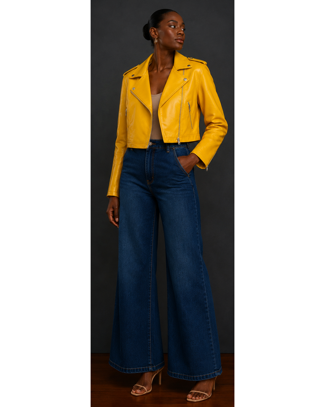 Front view of woman wearing a yellow leather jacket and blue jeans on a plain background
