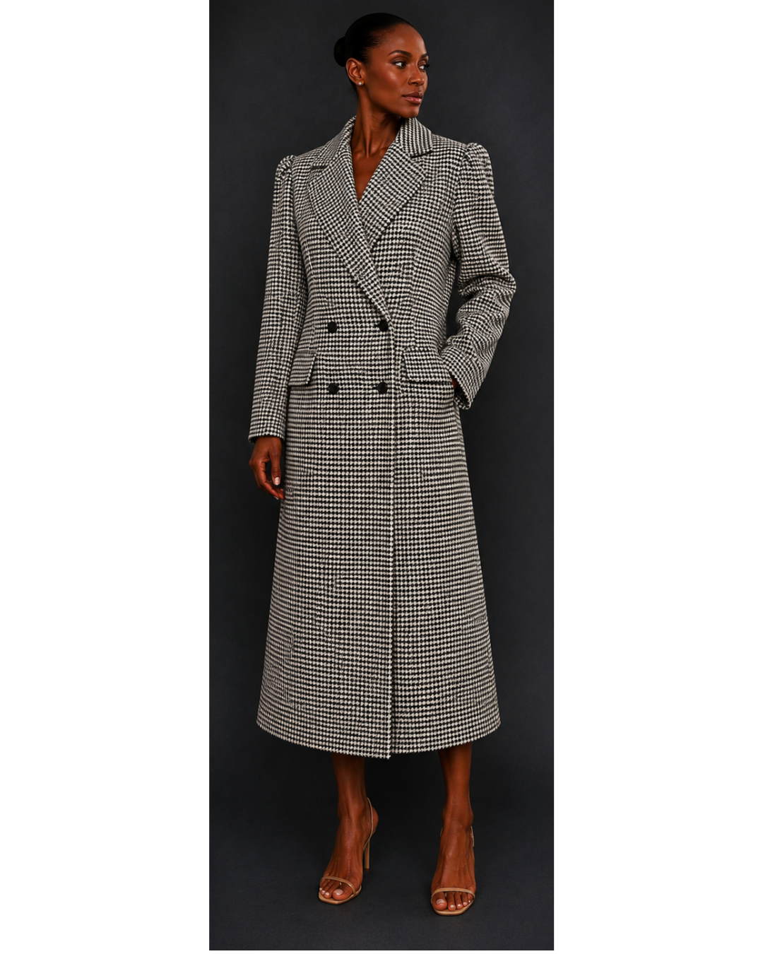 Woman wearing a long, houndstooth coat against a dark background