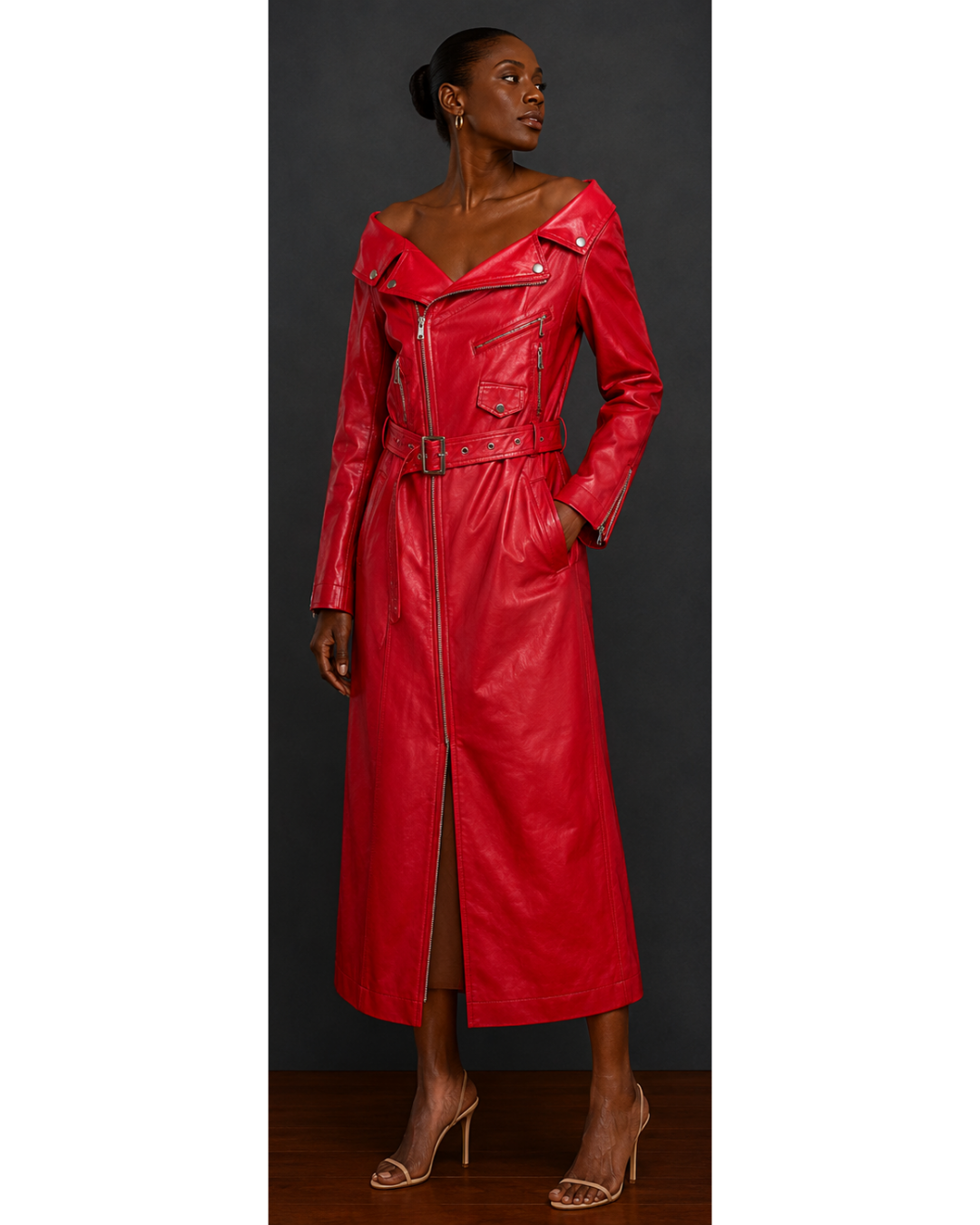 Red leather moto style trench coat dress worn by a model on a gray background