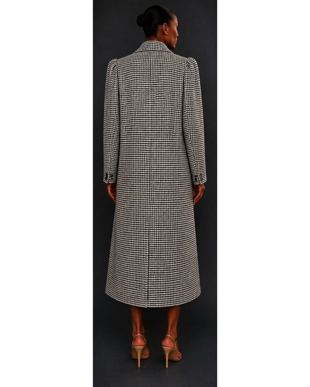 Woman wearing a long, houndstooth coat against a dark background
