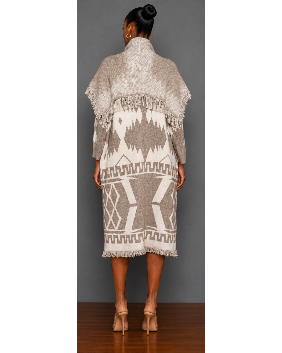 Woman wearing a neutral colored patterned blanket wrap coat with a plain charcoal gray background