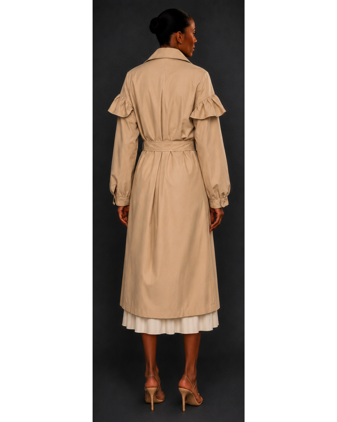 Woman wearing a beige trench coat on a black background