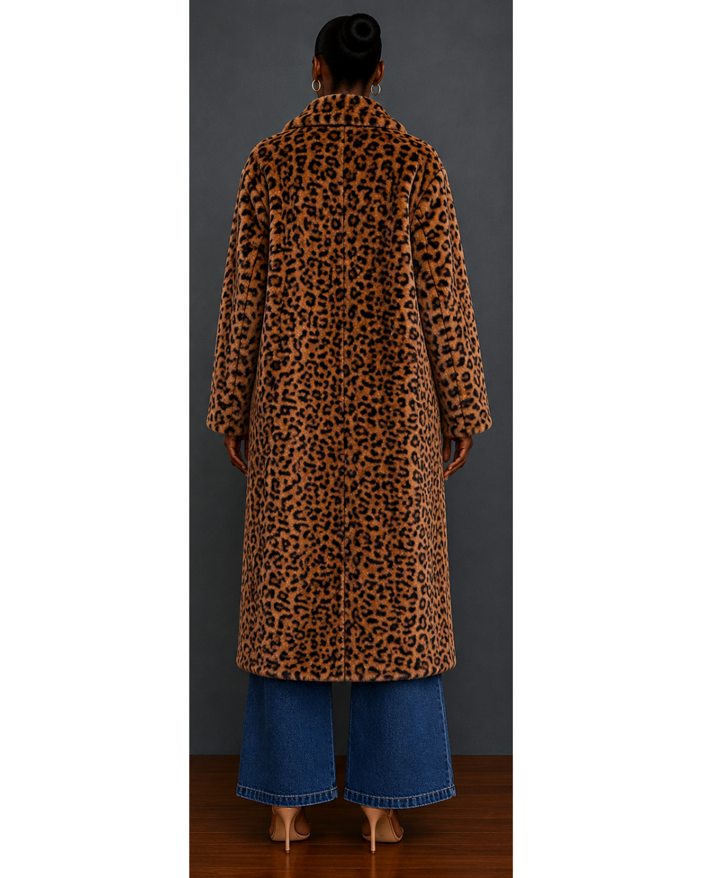 Back view of woman wearing a leopard print faux fur coat and blue jeans against a gray background