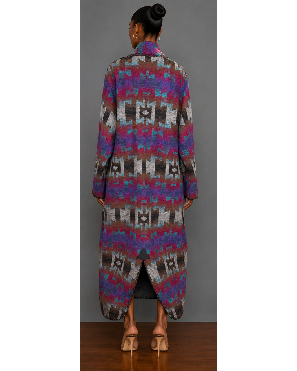 Back view of woman wearing a teal, red, brown, brown, gray, purple, and black patterned blanket wrap coat with collar and back hem slit