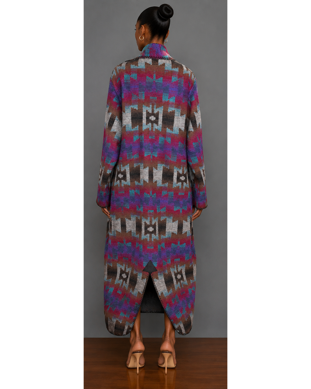 Back view of woman wearing a teal, red, brown, brown, gray, purple, and black patterned blanket wrap coat with collar and back hem slit